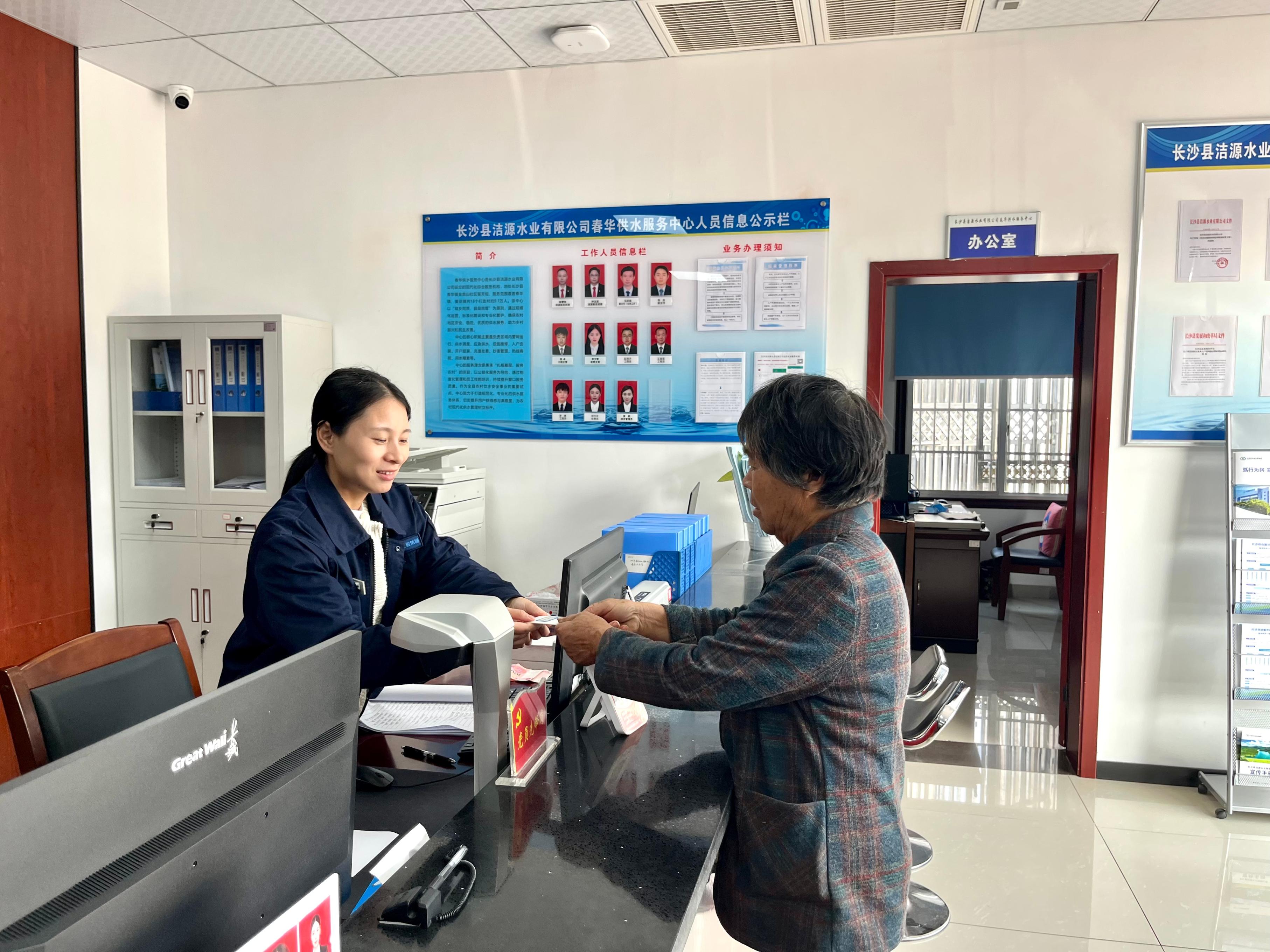春华供水服务中心工作人员为群众办理水费充值业务。受访者供图