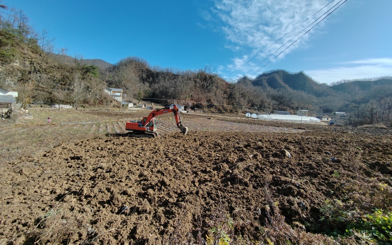 挖掘机对烟田开展深翻作业。李洪久摄