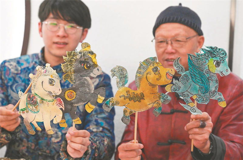 马飞（右）和他的徒弟展示影偶。